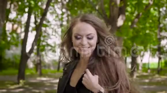 在一个温暖的夏日里一个年轻漂亮的女人带着一头黑发走在街上脸上挂着微笑视频的预览图