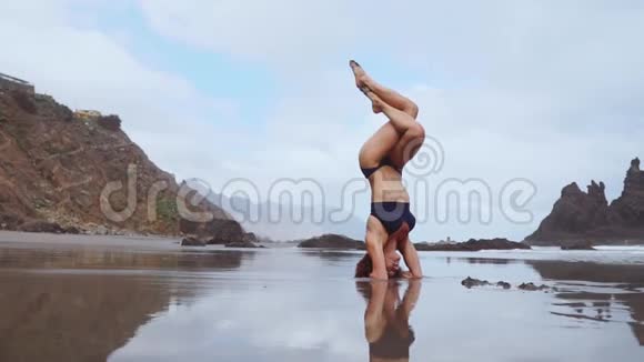 运动女孩站在海洋上的头上双腿在空中移动视频的预览图