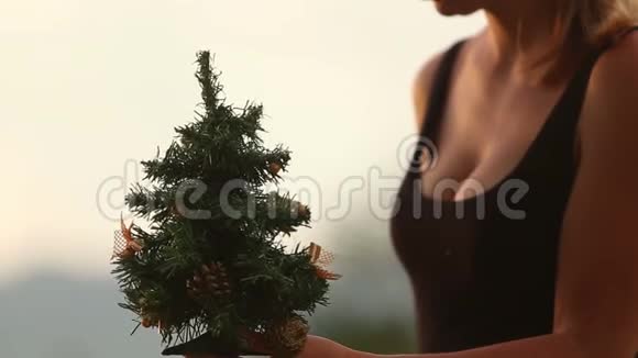 女孩把雪人挂在圣诞树上视频的预览图