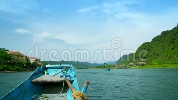 漂浮在热带河流上的蓝色木船视频的预览图
