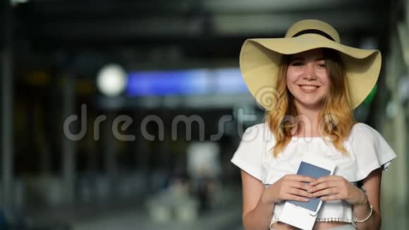 夏帽漂亮正在机场等一架飞机手里拿着护照和机票视频的预览图