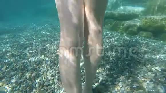女性的脚踩在温泉的水下石头上视频的预览图