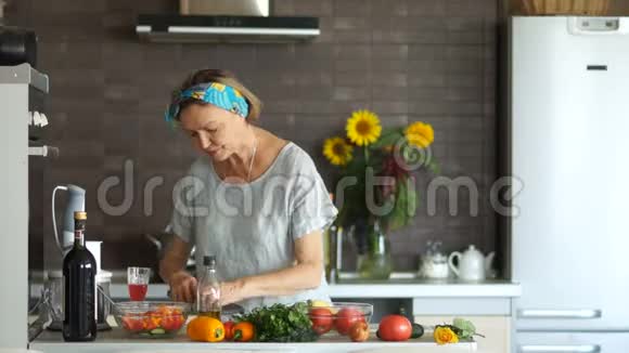 厨房里的老年退休金领取者准备了一份沙拉并把它装满了植物油健康的食物素食主义视频的预览图