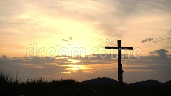 概念木十字或宗教符号形状在日落天空与云背景的上帝视频的预览图