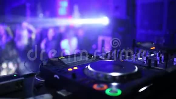 一个专业的DJ在一个聚会上的俱乐部工作使一群人和音乐混合在一起DJ遥控特写视频的预览图