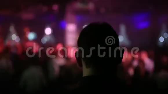 从后面近距离观看DJ的头像并在模糊的背景下在派对上跳舞朱迪视频的预览图