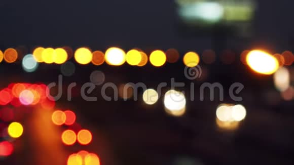 从城市街道上行驶的汽车的灯光上移动bokeh圆圈城市模糊背景夜间交通视频的预览图