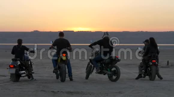 骑自行车的人在湖河海湾上乘着日落摩托车手穿过沙漠视频的预览图