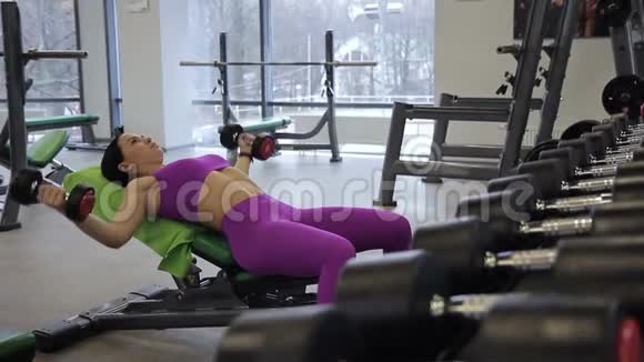 在健身房女人用两个哑铃训练手臂肌肉视频的预览图