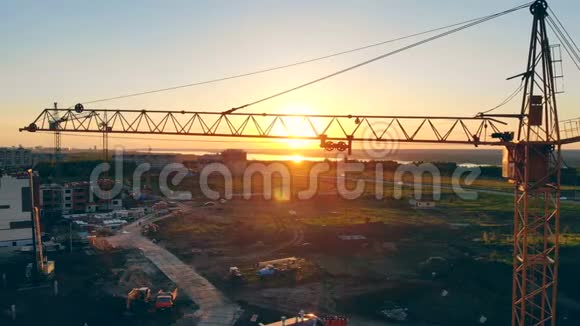 起重起重机正站在建筑区房地产概念日落时的工地视频的预览图