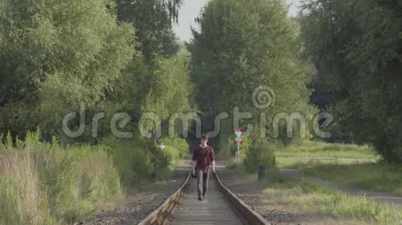 年轻人走在老火车轨道上视频的预览图
