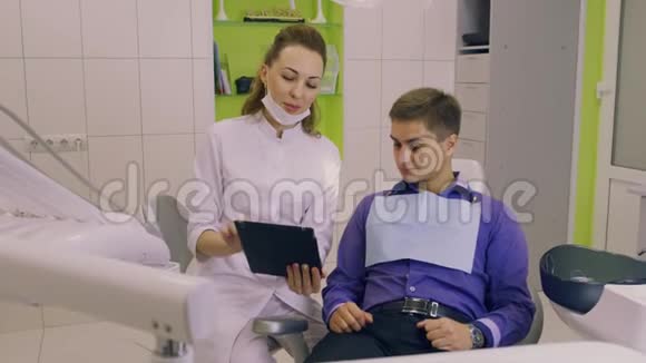 有吸引力的牙医带着药片与病人交流视频的预览图