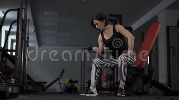 健身馆里的年轻健康女子在做运动视频的预览图