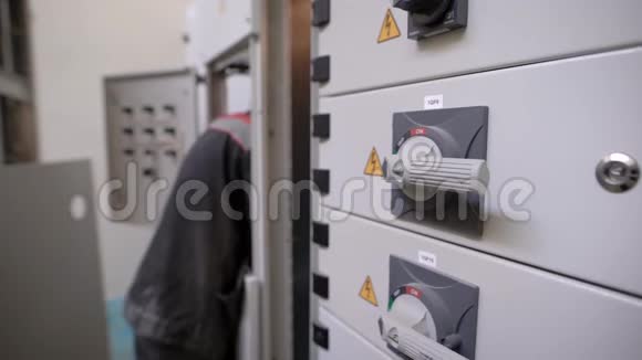 电工在一个大工业中工作一个配电板一个带手柄的封闭开关板视频的预览图