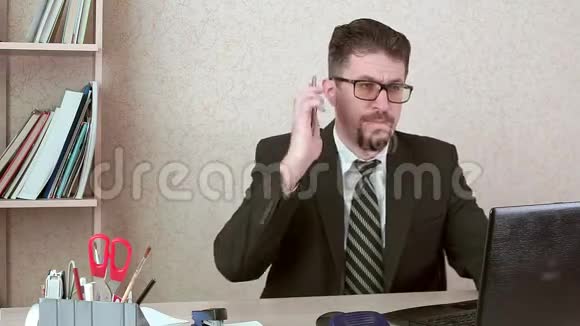 一位留着胡子和眼镜的上班族在智能手机上和客户交谈视频的预览图