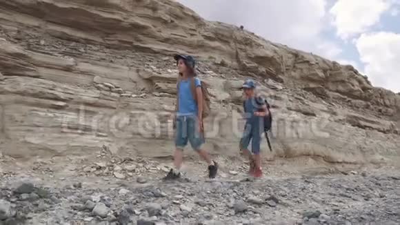 孩子们是徒步旅行的旅行者一个带背包的小游客正沿着山区的地形散步视频的预览图