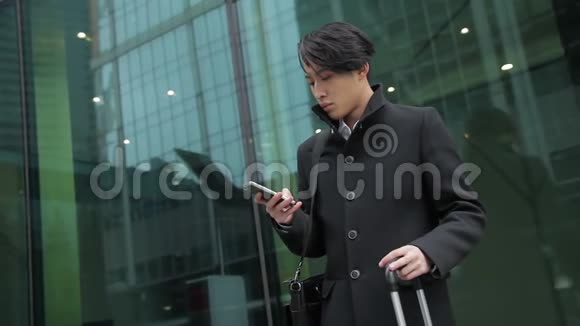 这名韩国男子站在机场附近在手机上输入信息视频的预览图