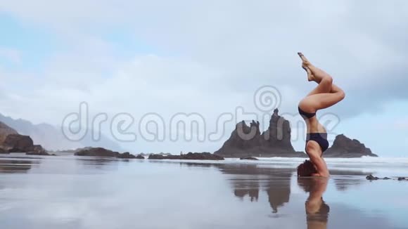 运动女孩站在海洋上的头上双腿在空中移动视频的预览图