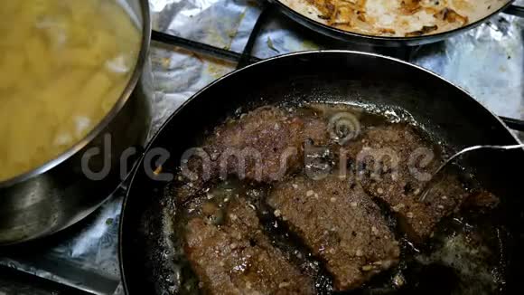 煮熟的意大利面管和牛肉肝或肉排是在厨房的炉子上准备的视频的预览图
