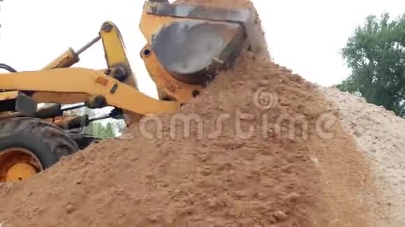 一辆黄色的大装载机把一桶土倒出地面装载机视频的预览图
