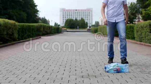 一个男人用一包垃圾踢他的脚垃圾在市中心视频的预览图