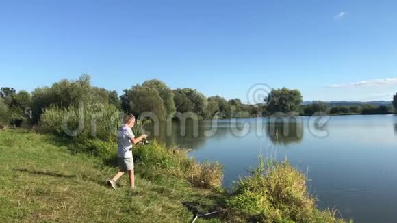 在湖边钓鱼的男孩美丽的鱼塘巴丁附近班斯卡比斯特里察斯洛伐克捕鱼的地方视频的预览图