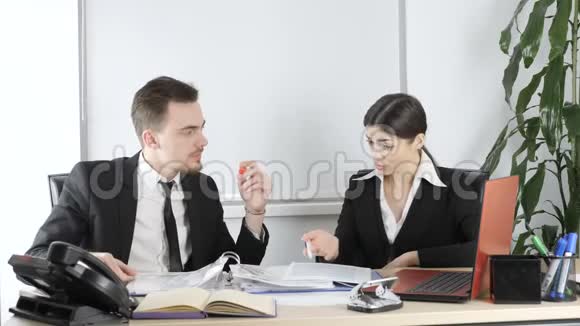 一个年轻的男人和一个穿西装的女人在办公室讨论一份合同商业上班族交易60个fps视频的预览图