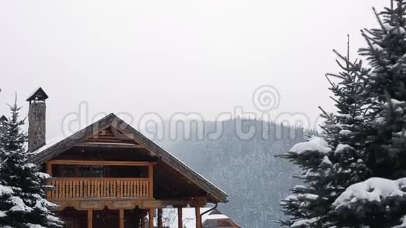 冬天下雪的时候山上的圣诞木大厦松林附近滑雪场的舒适小屋小屋视频的预览图