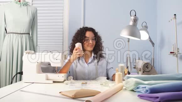 白种人妇女在工作场所裁缝线带线的筒管视频的预览图