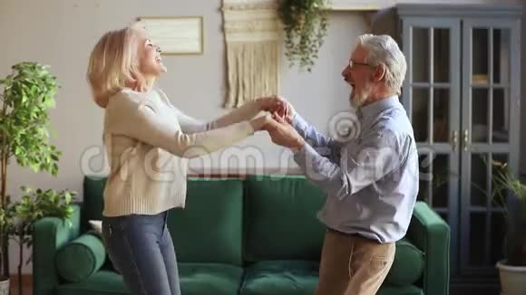快乐活跃的老夫妇在家一起跳舞玩得开心视频的预览图