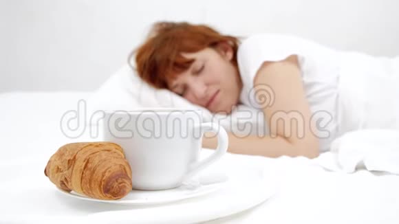 概念女性睡在床上和白色的咖啡杯白色背景视频的预览图