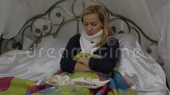 生病的女人咳嗽喝了一片药女孩躺在床上脖子上戴着一条温暖的围巾慢动作视频的预览图