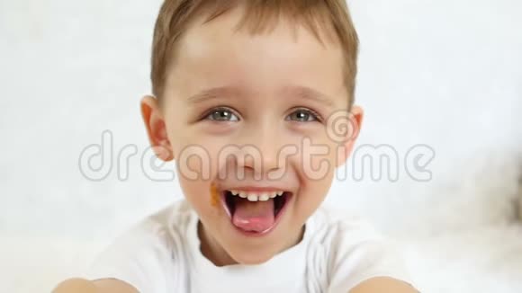 婴儿的特写镜头缓慢地看着镜头微笑着孩子露出喜悦露出舌头和灿烂的笑容视频的预览图