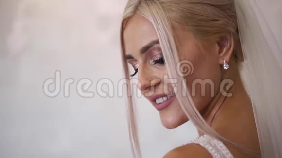 用时尚的妆容和发型来衬托美丽的新娘金发女孩视频的预览图