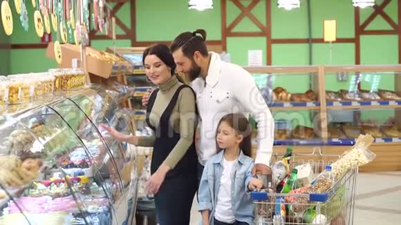 超市面包店选择面包和糖果的家庭画像视频的预览图