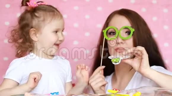 母女俩一起玩笑着戴眼镜吹角节日聚会生日的概念视频的预览图