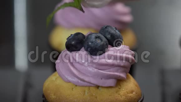 用蓝莓和薄荷装饰杯蛋糕美味松饼上的奶油视频的预览图