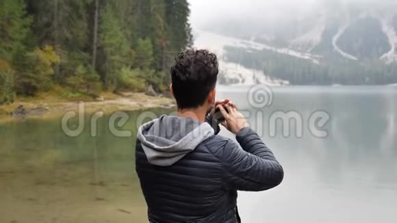 一个人在湖边用摄像机拍照视频的预览图