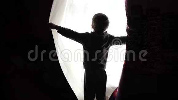 清晨孩子拉开窗帘阳光透过窗户日出视频的预览图