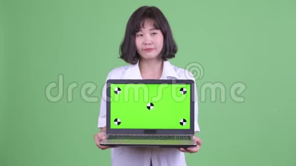 快乐美丽的亚洲女商人一边思考一边展示笔记本电脑视频的预览图