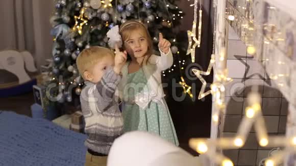 两个小孩在圣诞树附近玩耍视频的预览图