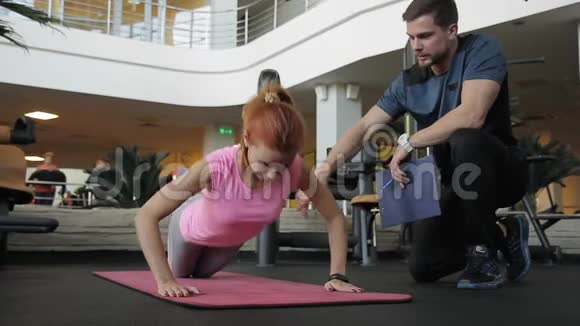女运动员与个人健身教练进行肌肉训练视频的预览图