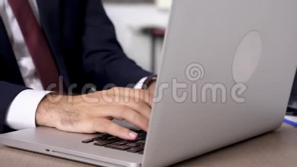 放大动态镜头关闭商人手在笔记本电脑键盘上快速打字视频的预览图