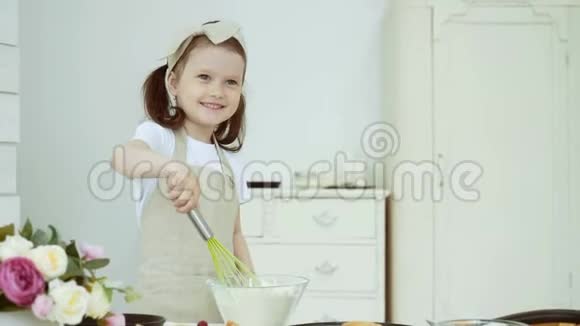 小女孩用玻璃碗搅拌面粉视频的预览图