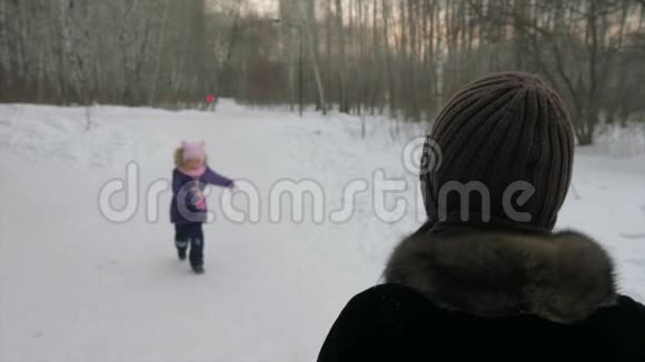 小女儿在雪地上跑到妈妈身边拥抱妈妈亲吻妈妈快关门视频的预览图