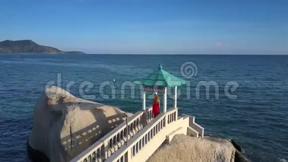 女孩站在海上的岩石上与天际线视频的预览图