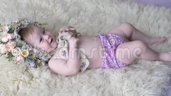 可爱的孩子戴着花圈躺在地毯上在摄影镜头前摆姿势视频的预览图