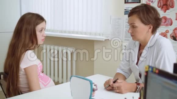 快乐美丽的年轻怀孕女孩在办公室的医生接待视频的预览图