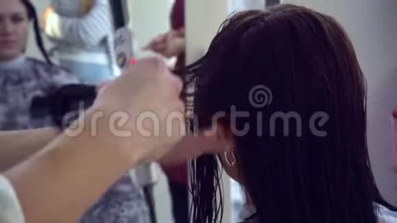 美容院理发店发型师给理发女孩做热剪发型师进行大师班特写镜头视频的预览图