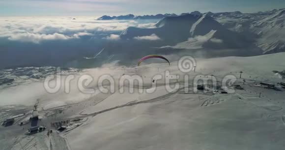 令人惊叹的空中视频在雪山上的Paplane滑翔伞冬季山区的特写无人机视频的预览图